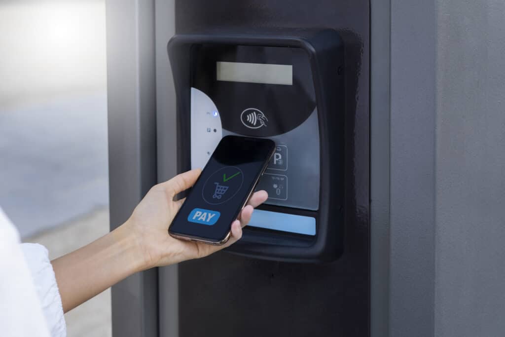 A women holding a mobile to RFDI sensor to pay a bill