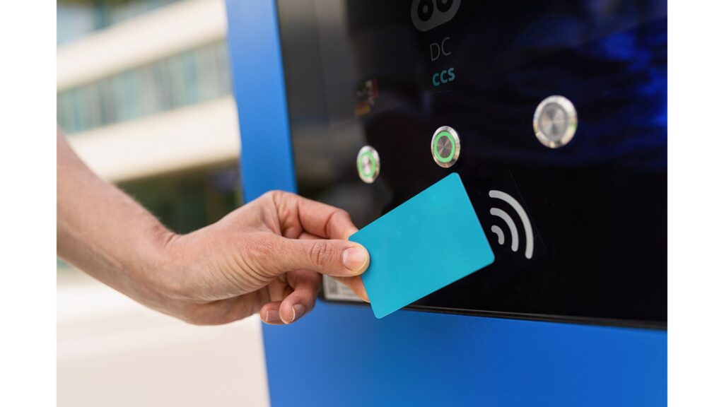 A picture of a rfid scanner device with a blue frame where a hand tapping a card to rfid card scanner. 