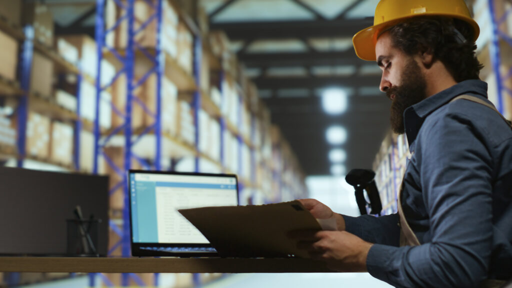 inventory manager examines order details gain using a rfid Bluetooth reader, working in industrial storage room to ensure shipment in time. Customs compliance staff checks stock tags at import export depot.