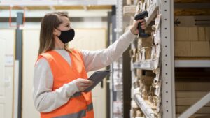 woman-wearing-face-mask using a Handheld RFID Reader in a Warehouse checking products