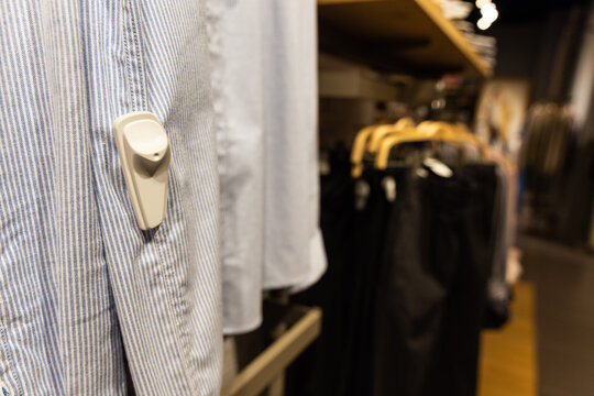 An ink tag attached to a clothing, hanging on at a store. 