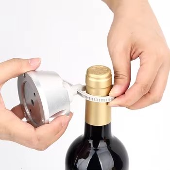 Close-up of someone securing a silver, some bottle-top wine bottle tags around the neck of a wine bottle.